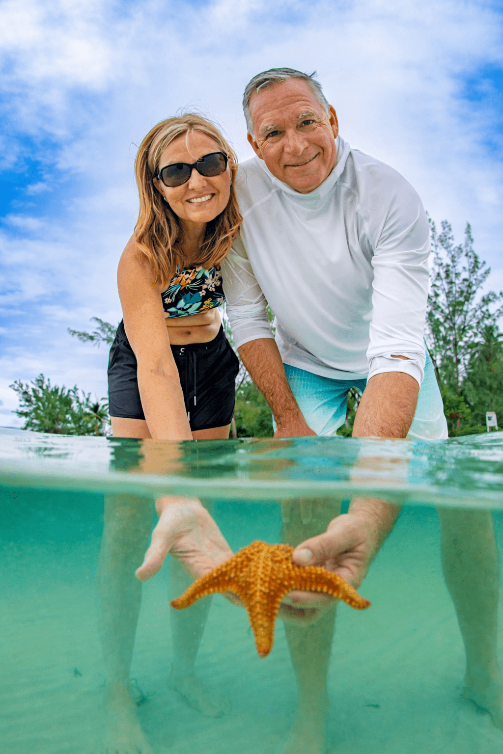 Red starfish in shallow turquoise water at Starfish Point beach